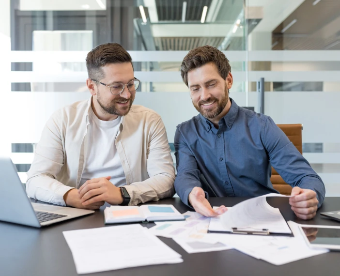 Image of executives seeing the reduced IT costs on paper