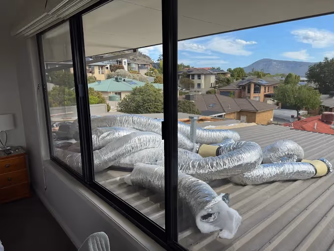 Ductwork installed on a roof outside a bedroom window.