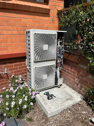 Mitsubishi outdoor air conditioning unit installed on a concrete base at a Canberra home