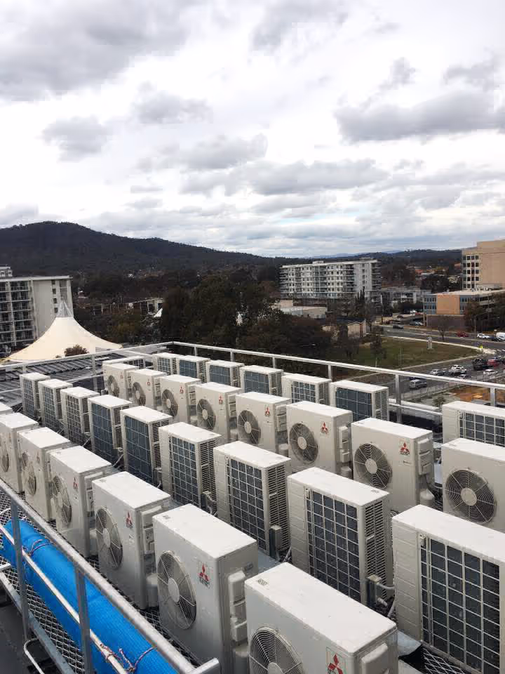 Multiple Mitsubishi air conditioners installed outside a commercial area