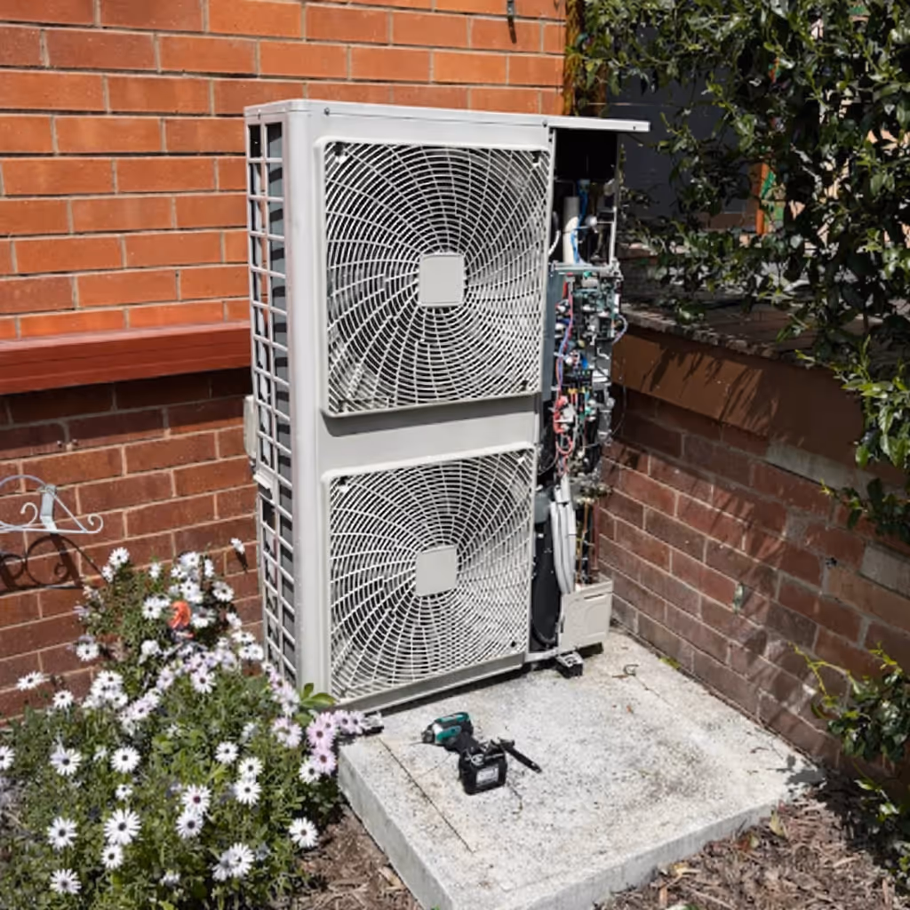 Residential air conditioning condenser installed near garden landscaping