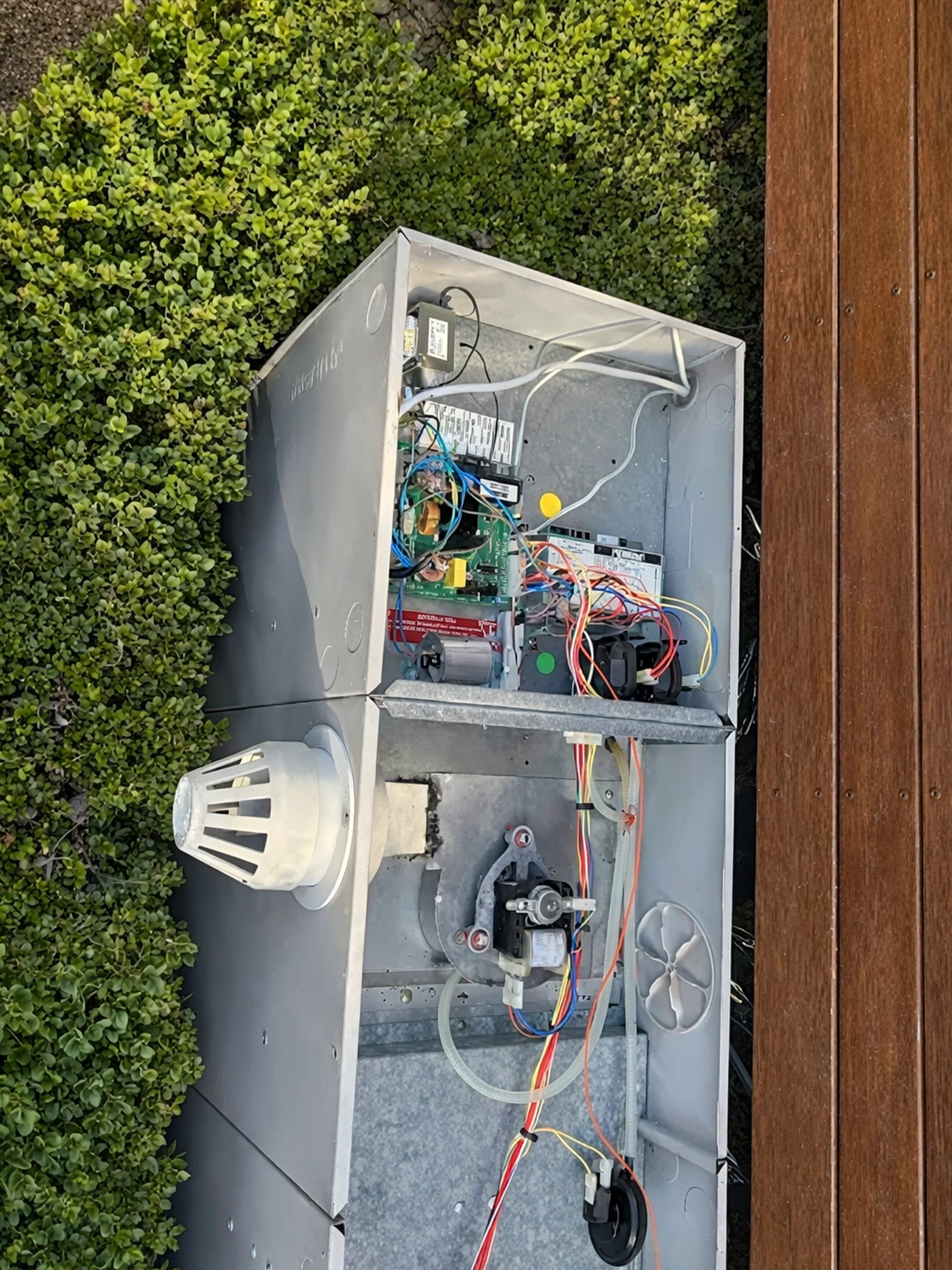 Open air conditioning unit showing internal electrical components during servicing.