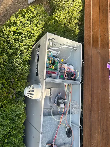 Air conditioning unit repair with internal components exposed in Kingston.