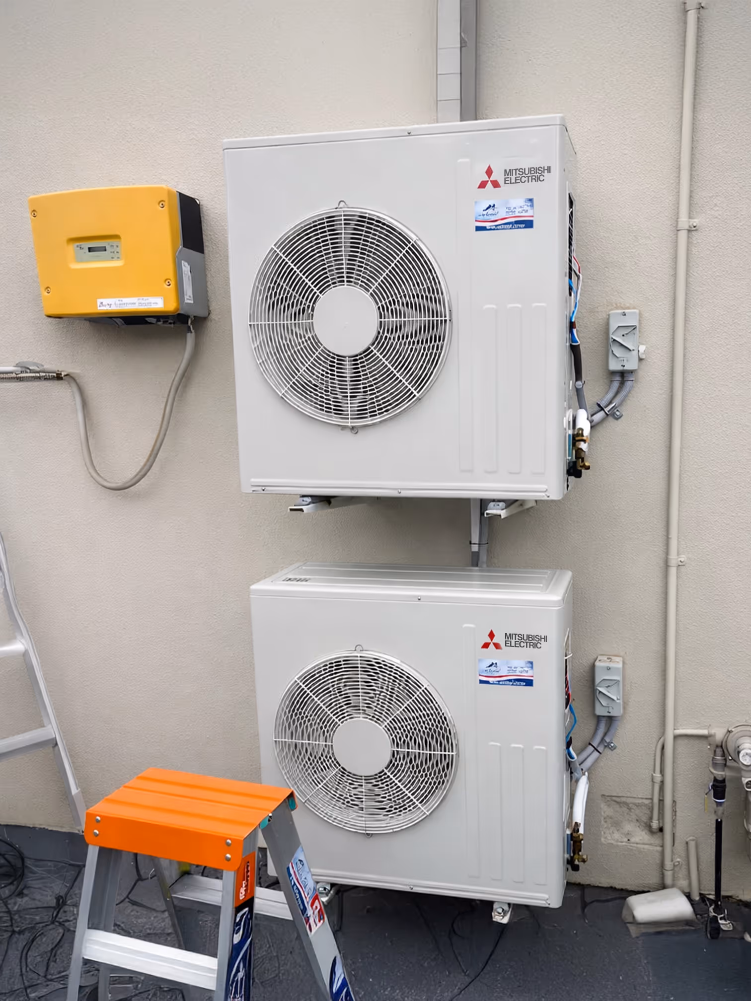 Wall-mounted outdoor air conditioning units installed at a residential property.
