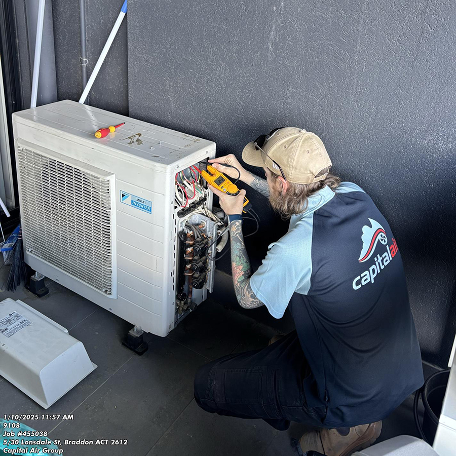 Capital Air technician repairing an outdoor air conditioning unit at a residential property in Gordon, ACT.