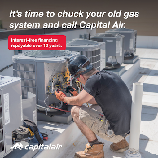 Technician servicing rooftop air conditioning units at a commercial site.