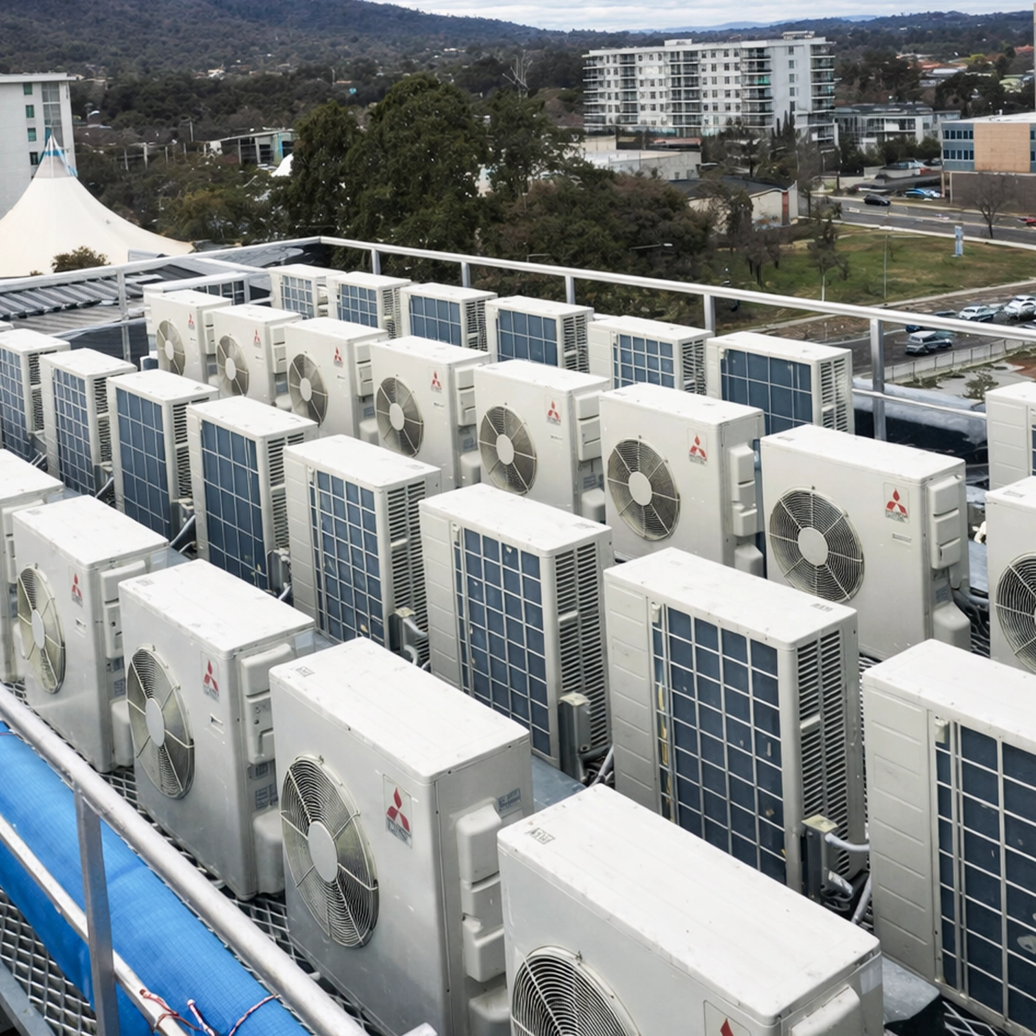 Rooftop installation of multiple air conditioning units on a commercial building in Canberra.