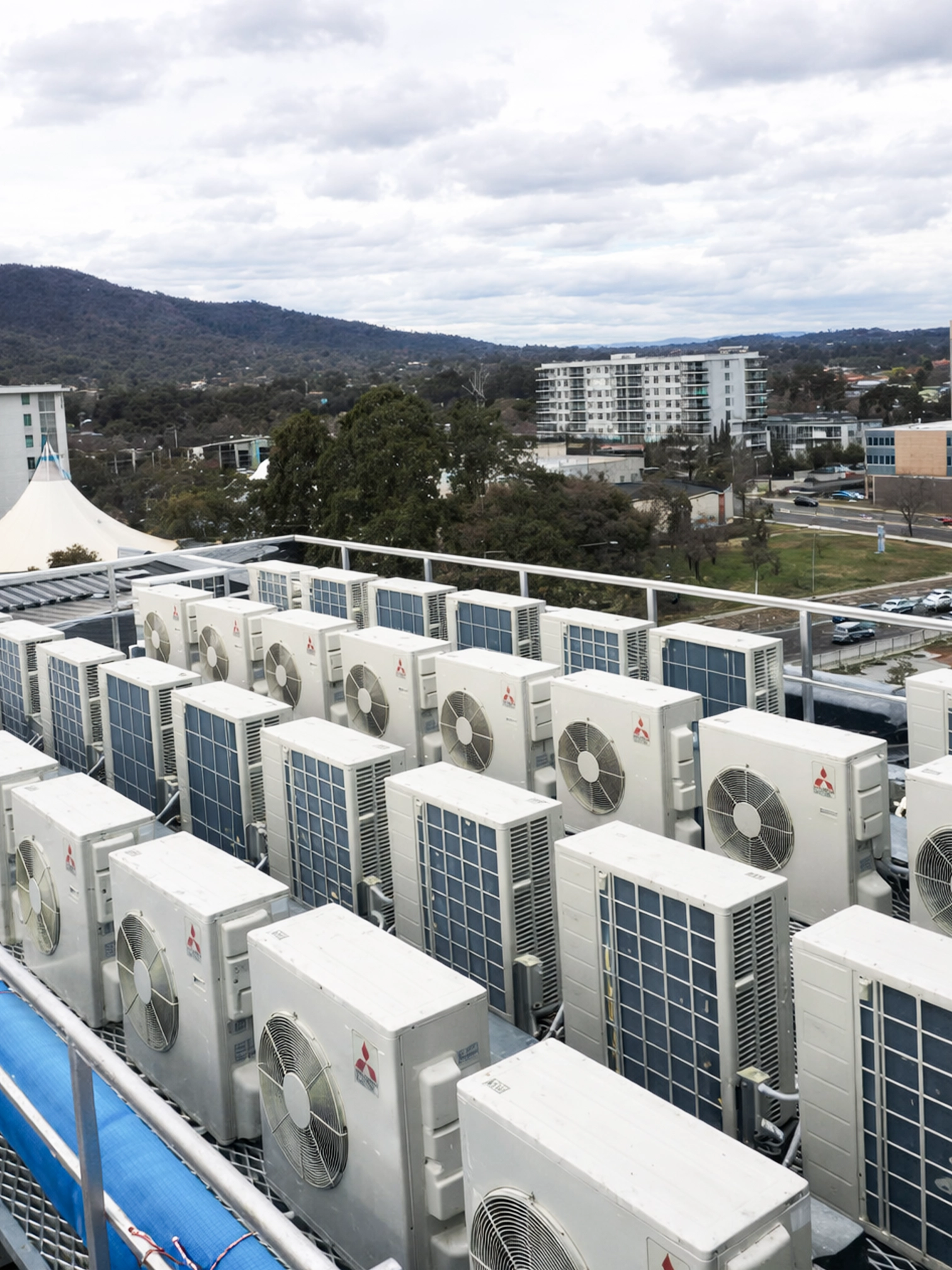 Multiple commercial air conditioning units installed on a rooftop in Canberra.