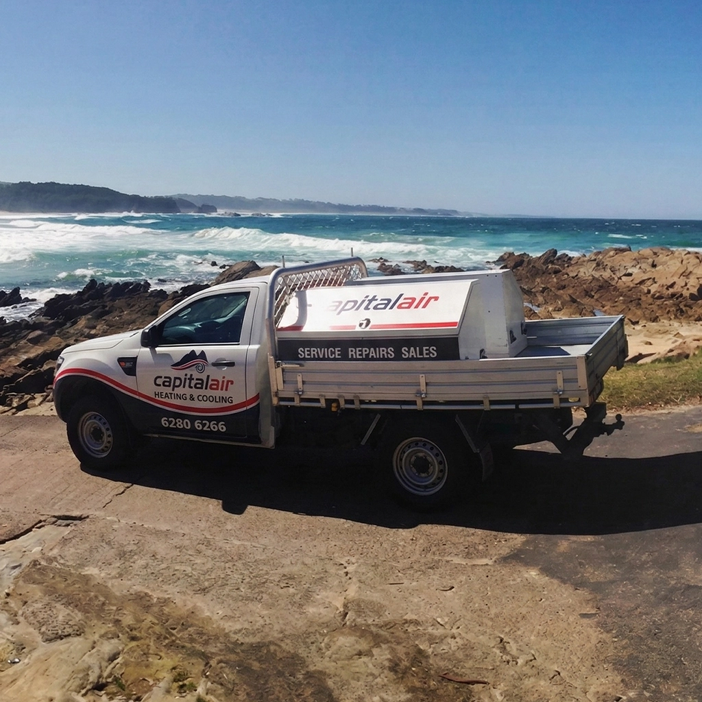 Capital Air service vehicle parked near coastline for air conditioning work.