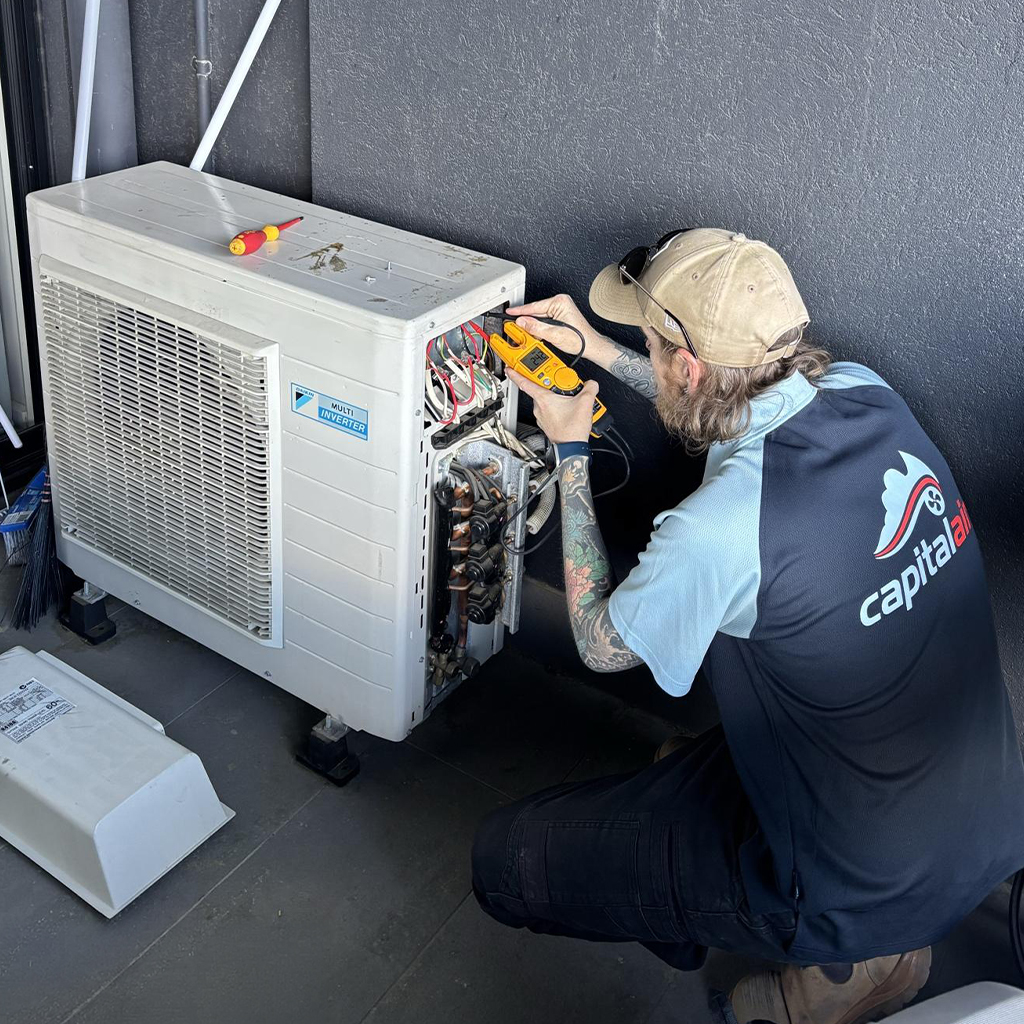 Capital Air technician testing an outdoor multi-split air conditioning unit.