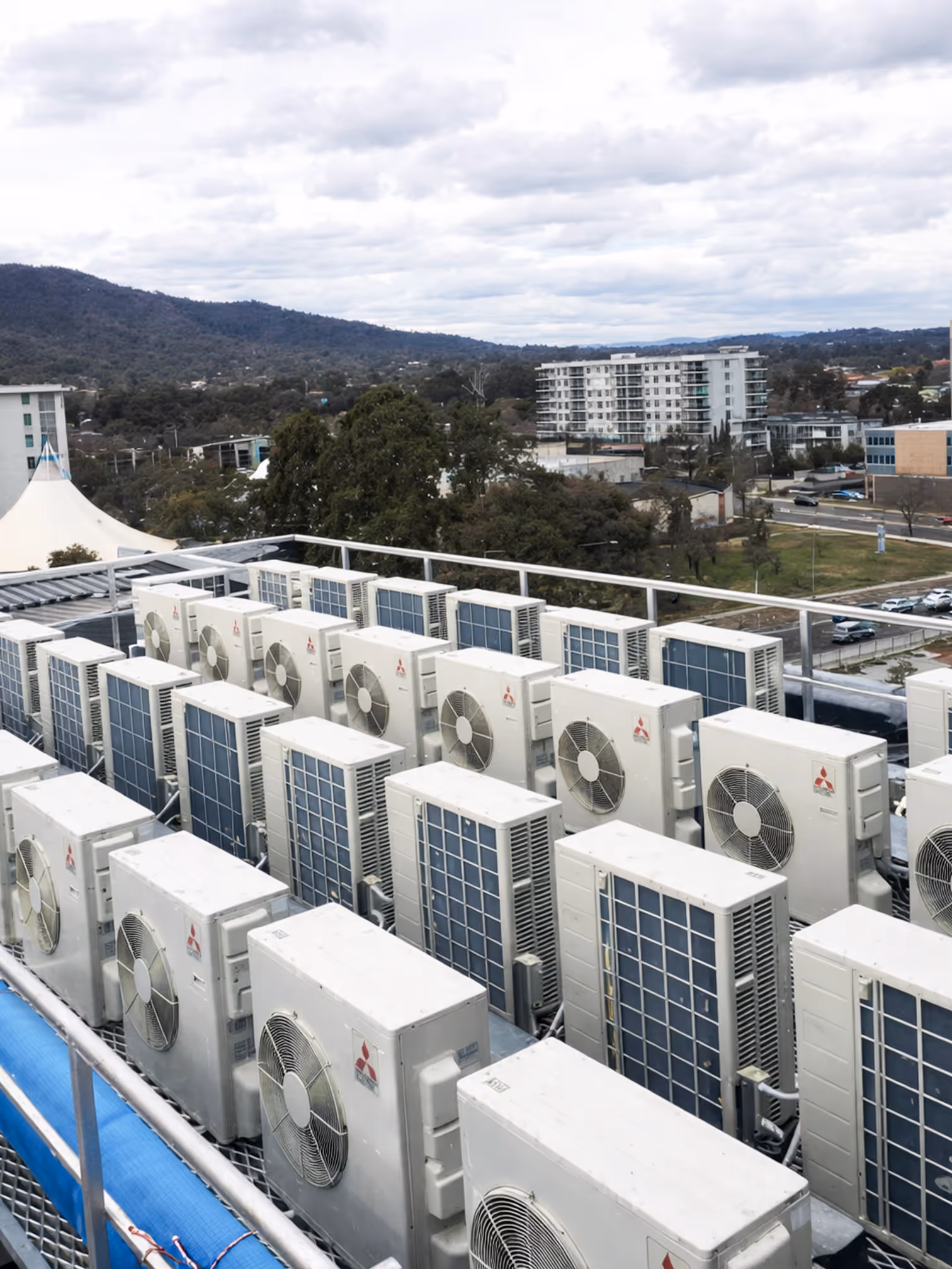 Multiple Mitsubishi Electric outdoor air conditioning units installed on a commercial rooftop.