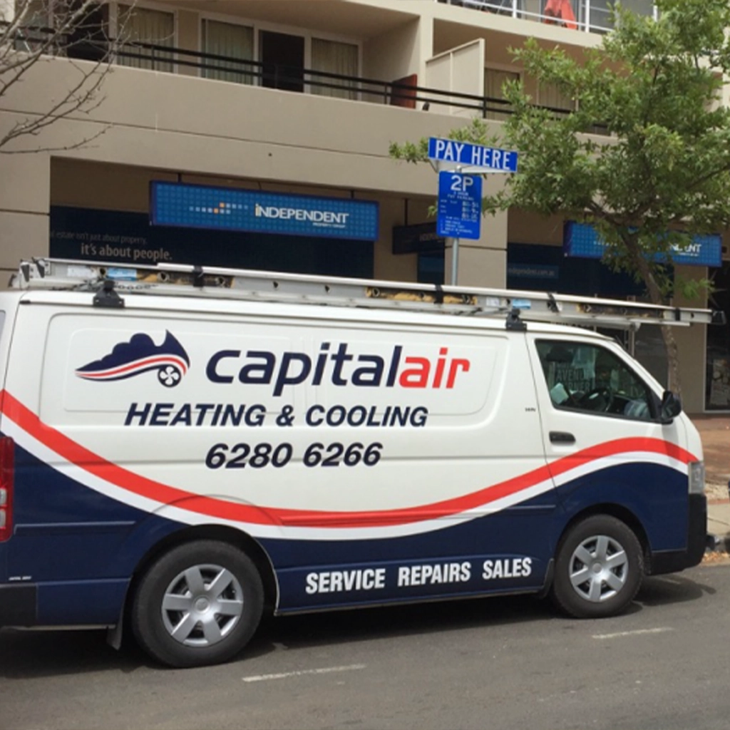 Capital Air service vehicles parked outside a commercial building.