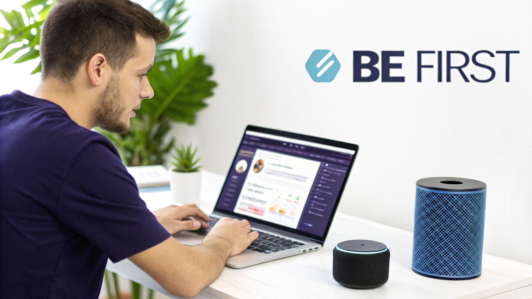 A man works on a laptop with a profile page open, flanked by smart speakers and a 'BE FIRST' logo.