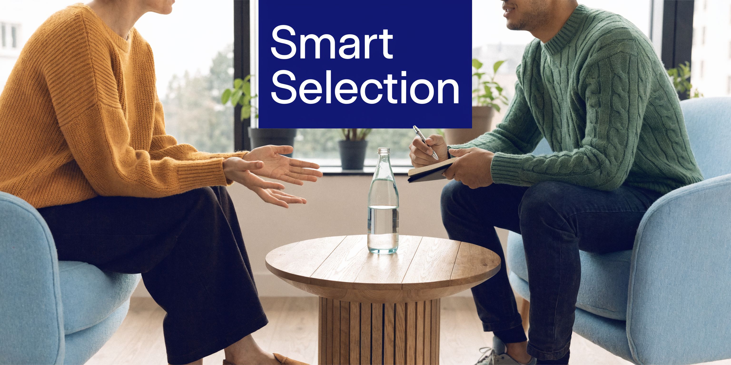A professional conversation occurring between two people seated in comfortable chairs during a business consultation meeting.