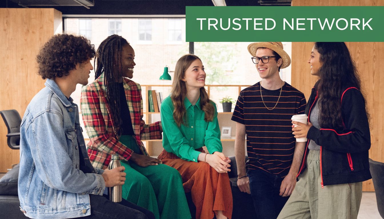 A diverse group of young professionals sitting in an office environment having a friendly conversation together.