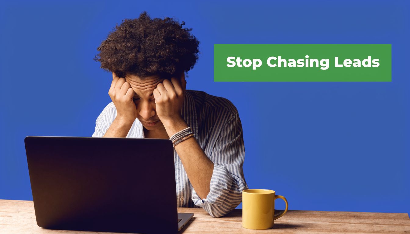 A person with curly hair sitting at a desk feeling stressed while looking at a laptop.