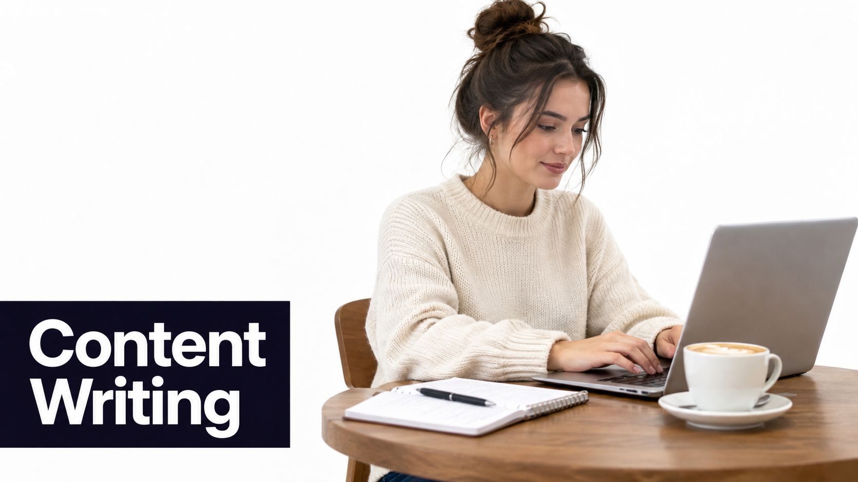 A young woman wearing a cream sweater working on her laptop with a notebook and coffee.
