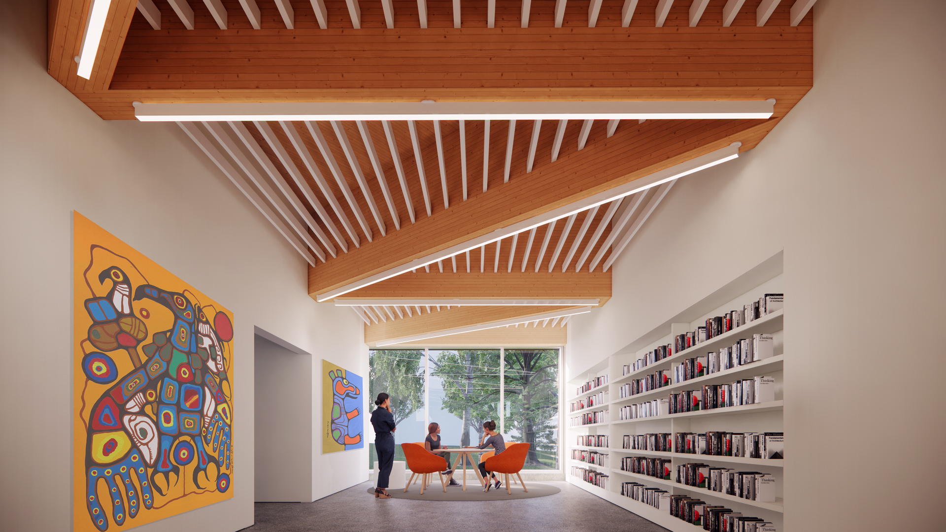 Modern reading room with wooden ceiling beams, large window, colorful wall art, book-filled shelves, and three people seated around a table.