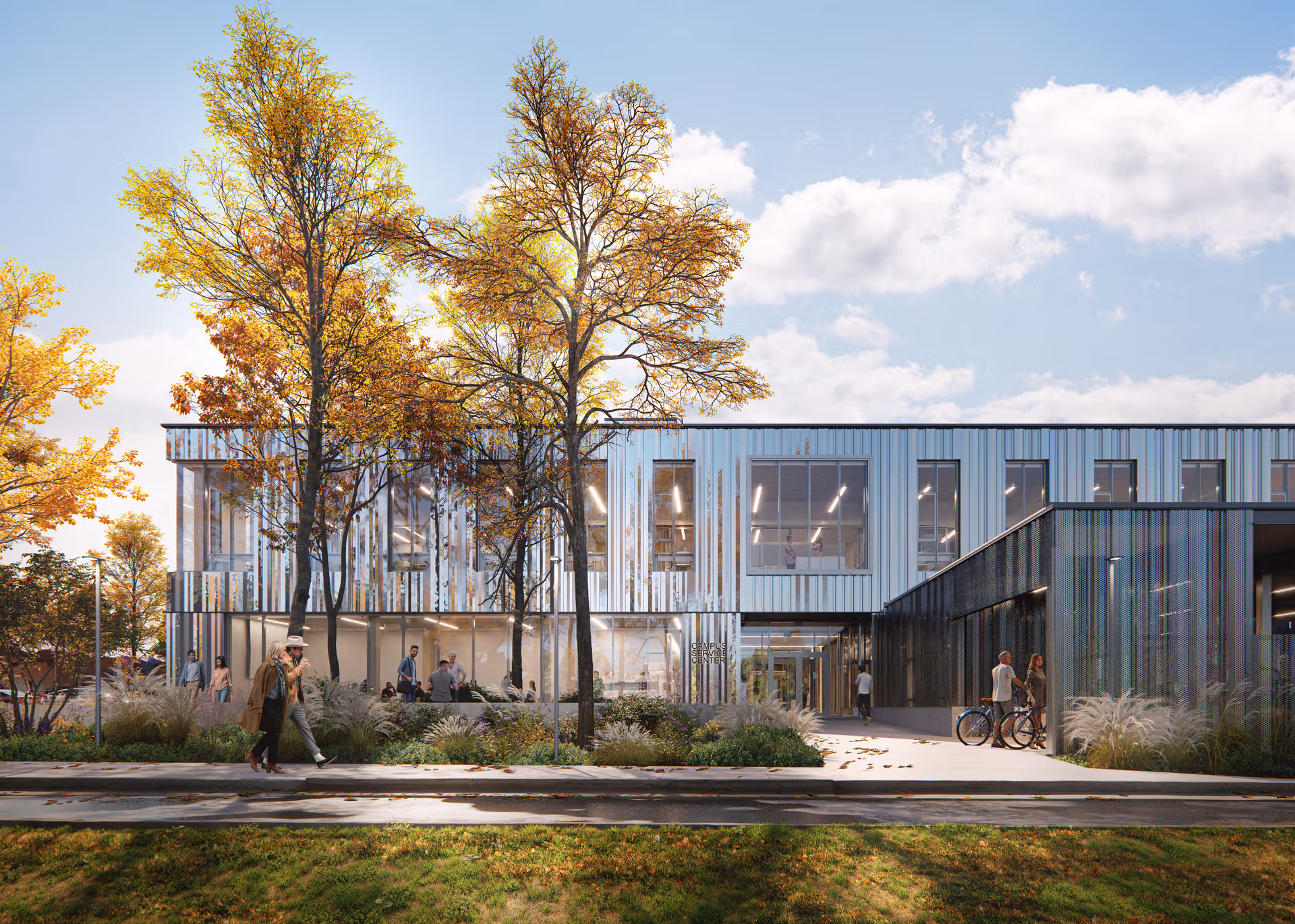 Modern two-story campus service center with large windows, people walking and cycling, and trees with autumn foliage.