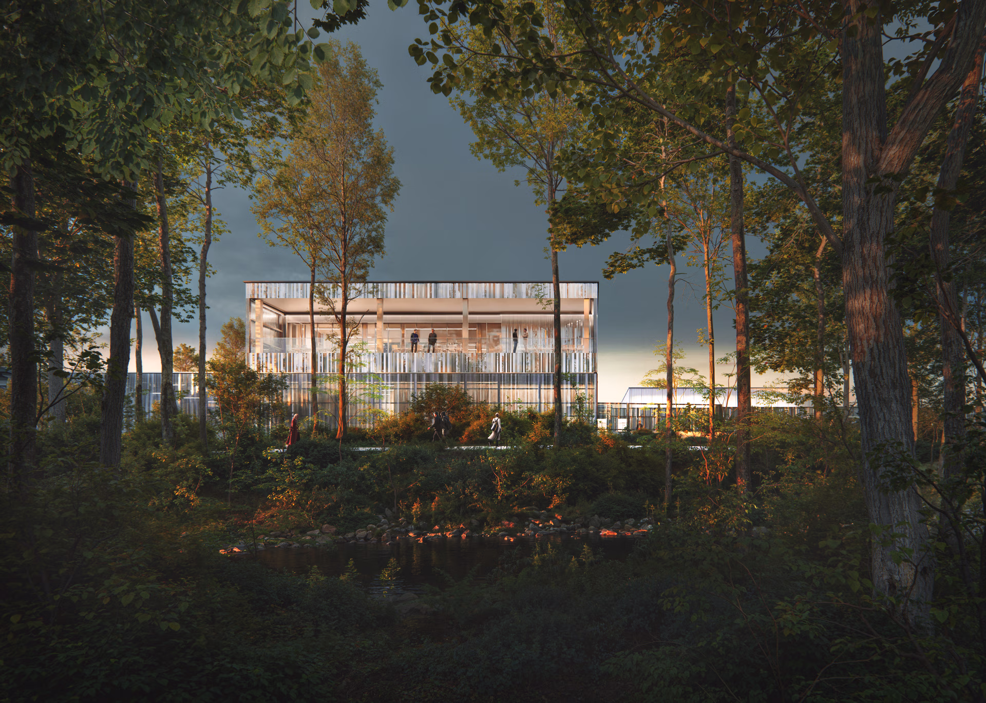 Modern glass building with visible people inside and outside, surrounded by tall trees and dense foliage at sunset.