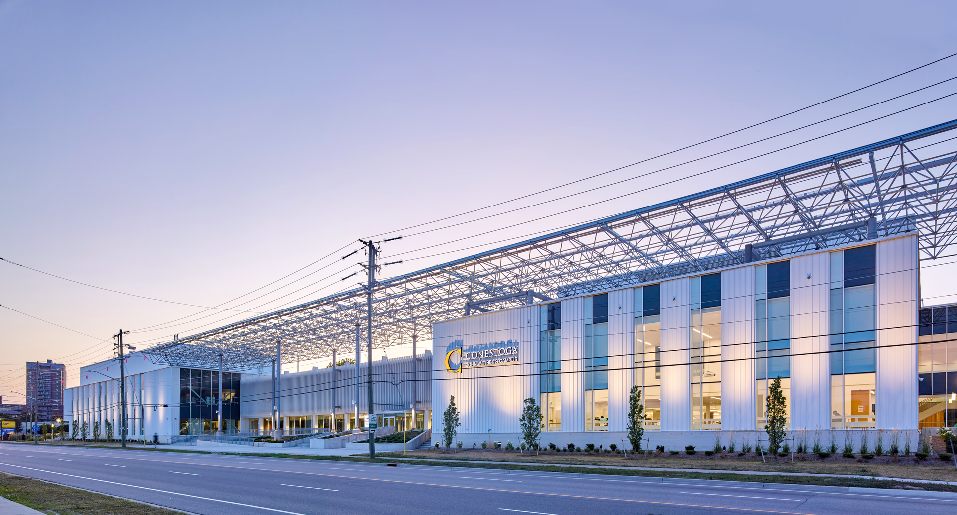 Modern Conestoga College John M. Bittis Campus building with large windows and metal framework under a clear sky.