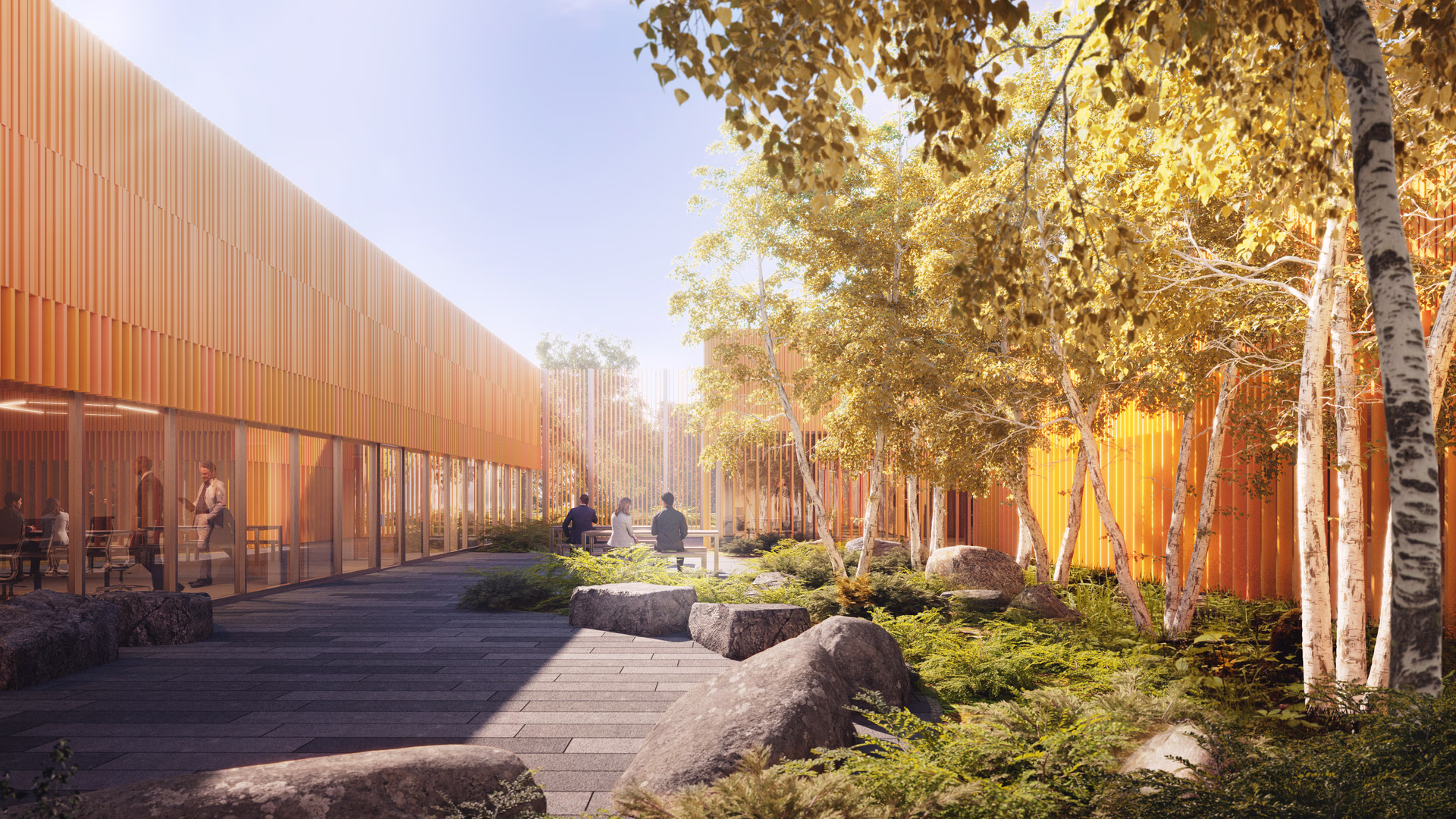 Outdoor courtyard with modern orange building, three people sitting at a table, large rocks, and birch trees with sunlight filtering through.