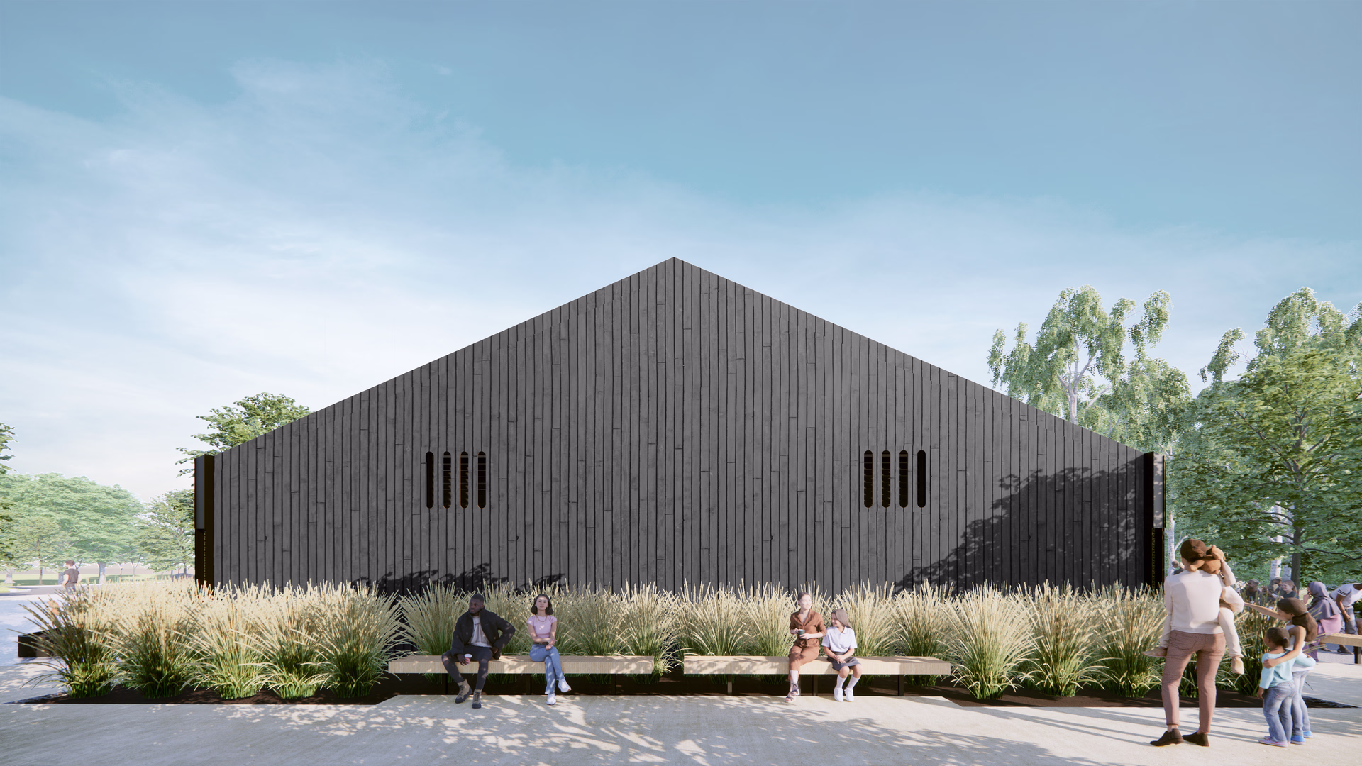 People sitting and standing near a large black wooden building with tall grass in front under a clear blue sky.