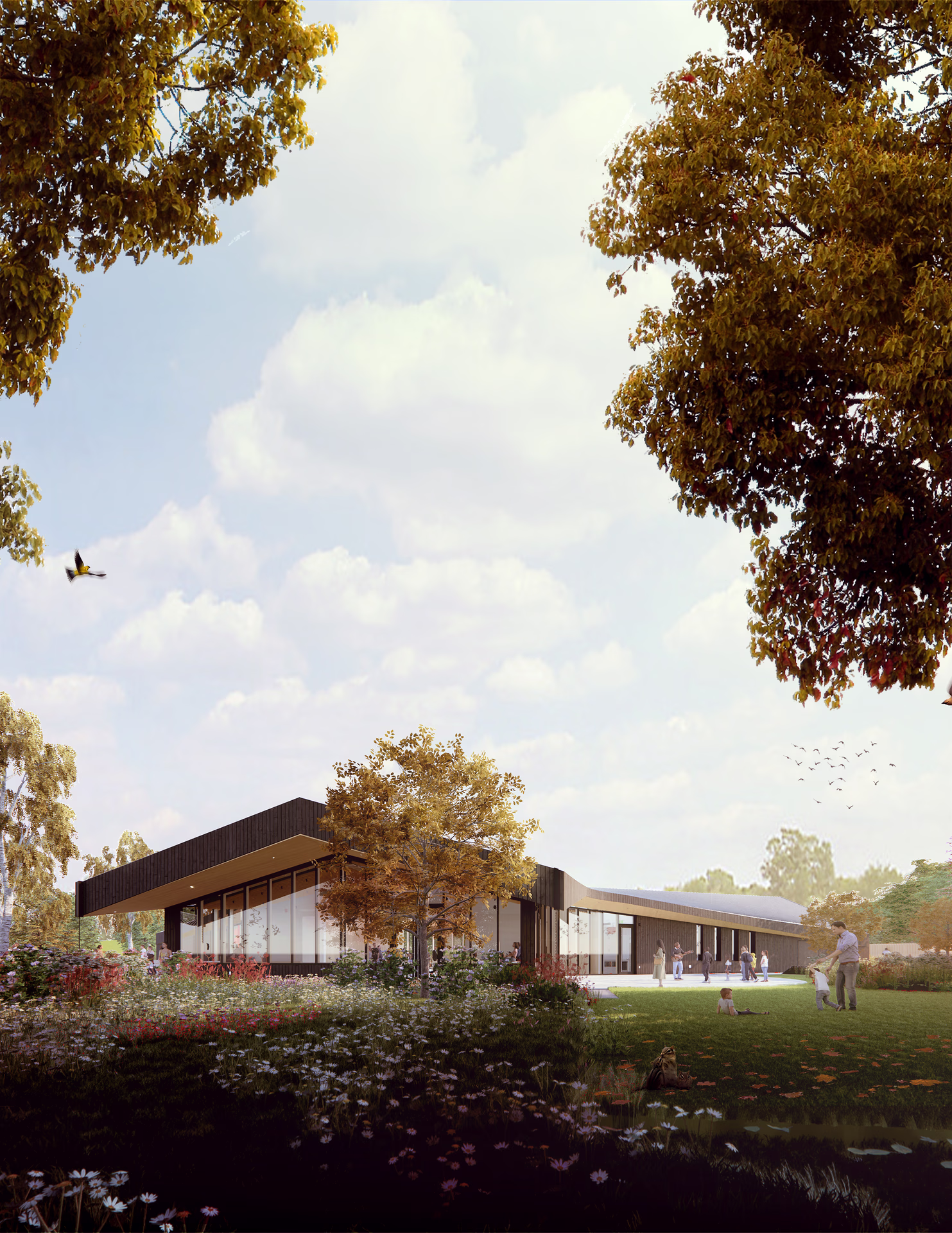 Modern single-story building with large glass windows surrounded by a grassy field with flowers, trees, and people enjoying the outdoor space.