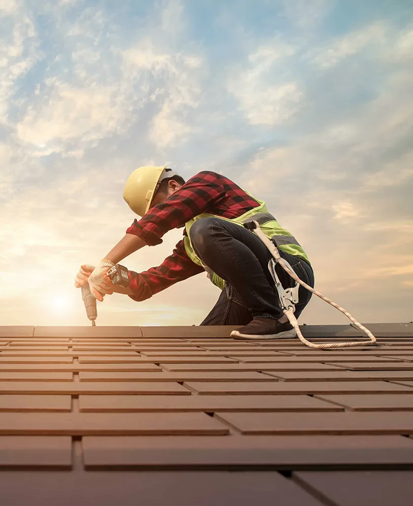 Roofer drilling in roof.