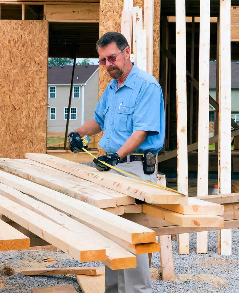Framing contractor measuring wood.