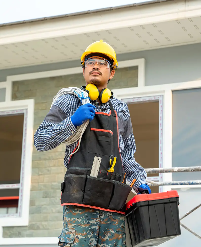 GC holding his tool box in front of a house.