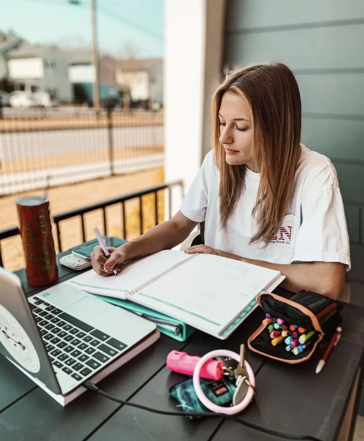 girl studying outdoors at table