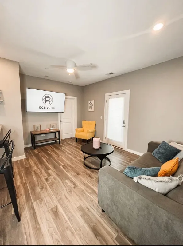 living area with sofa,tv and chairs at breakfast bar in kitchen