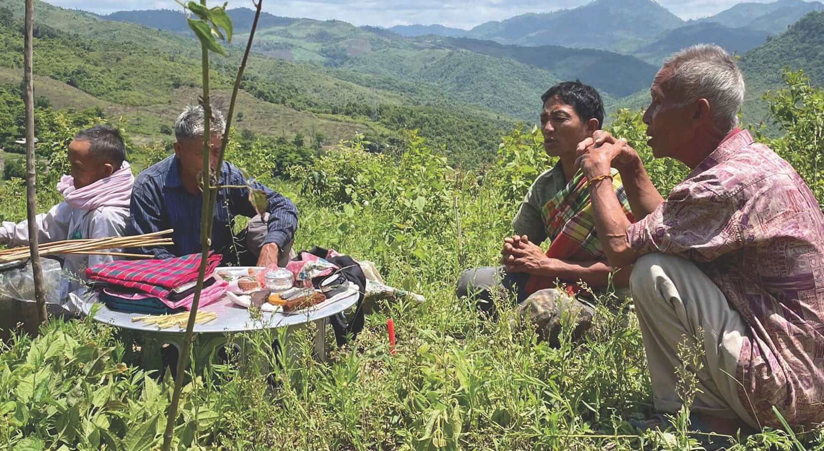 A group of unreached people sit together on a hillside