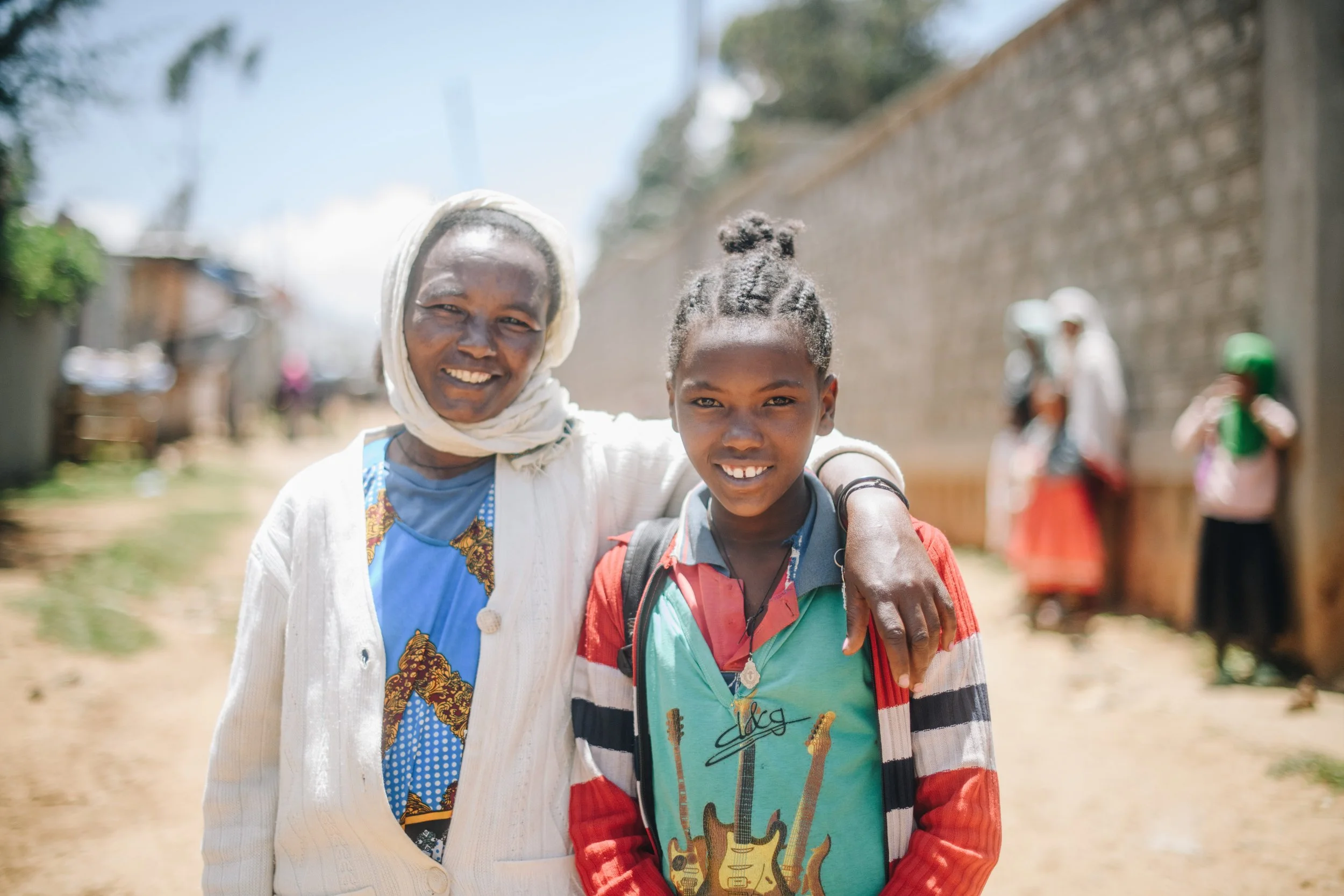 A woman with her arm around a young girl