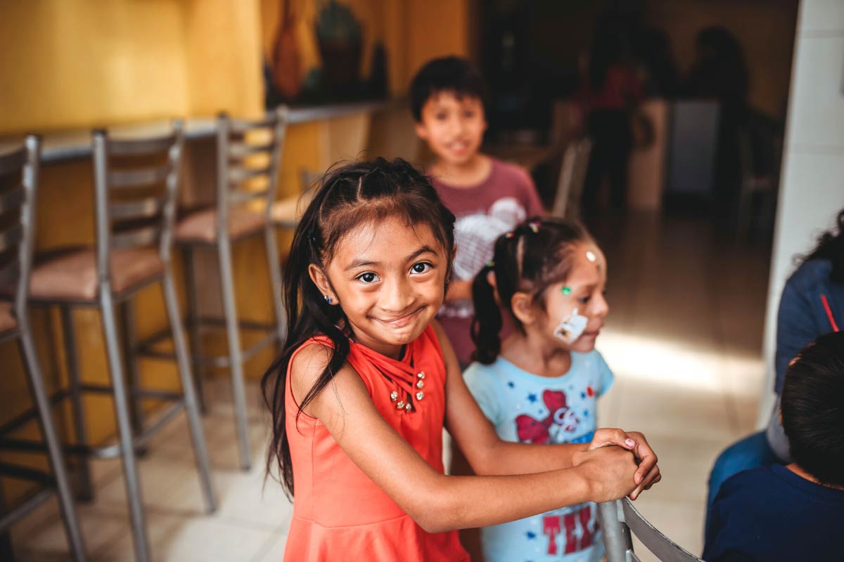 A child with cleft lip smiles at the camera