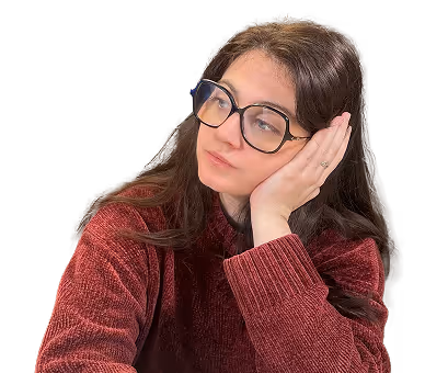 Jeune femme portant un pull bordeaux et de grandes lunettes, posant sa tête sur sa main avec une expression pensive.