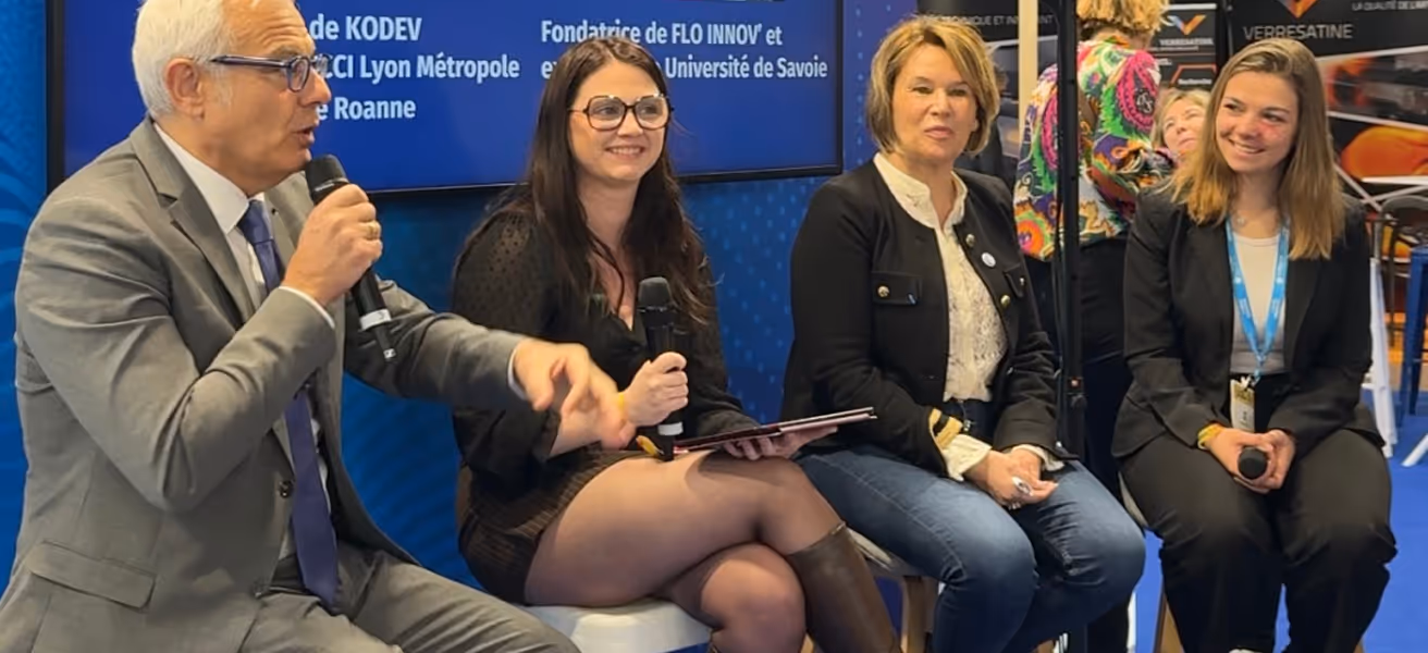 Quatre personnes assises lors d’une table ronde, dont un homme en costume gris parlant au micro et trois femmes l’écoutant.