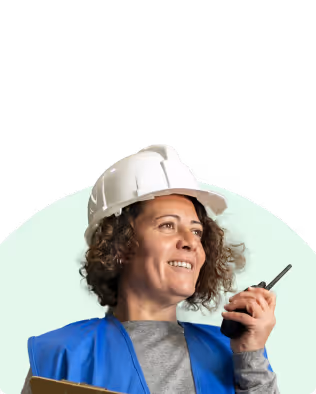 Femme souriante avec casque de sécurité blanc et gilet bleu tenant un talkie-walkie.