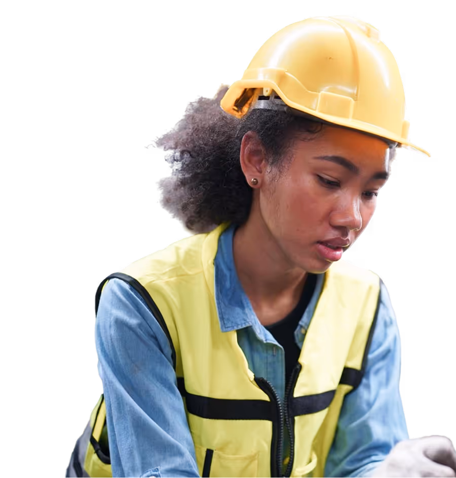 Femme portant un casque de chantier jaune et un gilet de sécurité réfléchissant, concentrée sur une tâche.