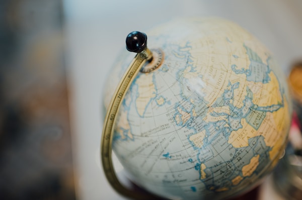 Close-up of a vintage globe showing parts of Europe, Africa, and the Middle East with a brass meridian.