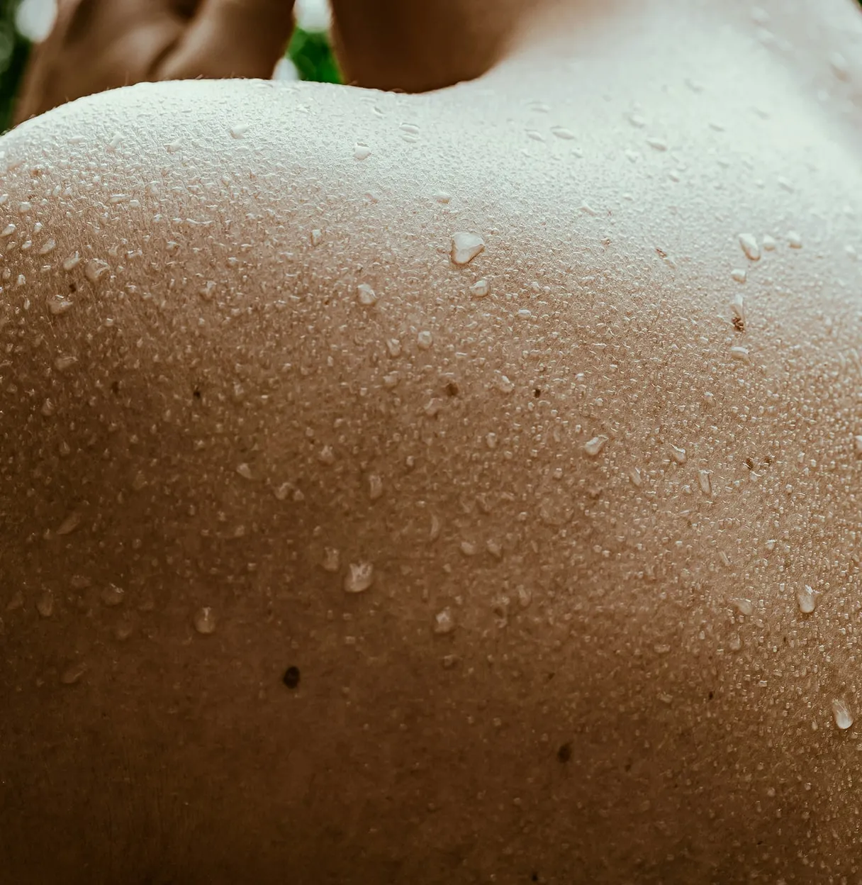 Close-up of wet, glistening skin with water droplets highlighting texture and pores.
