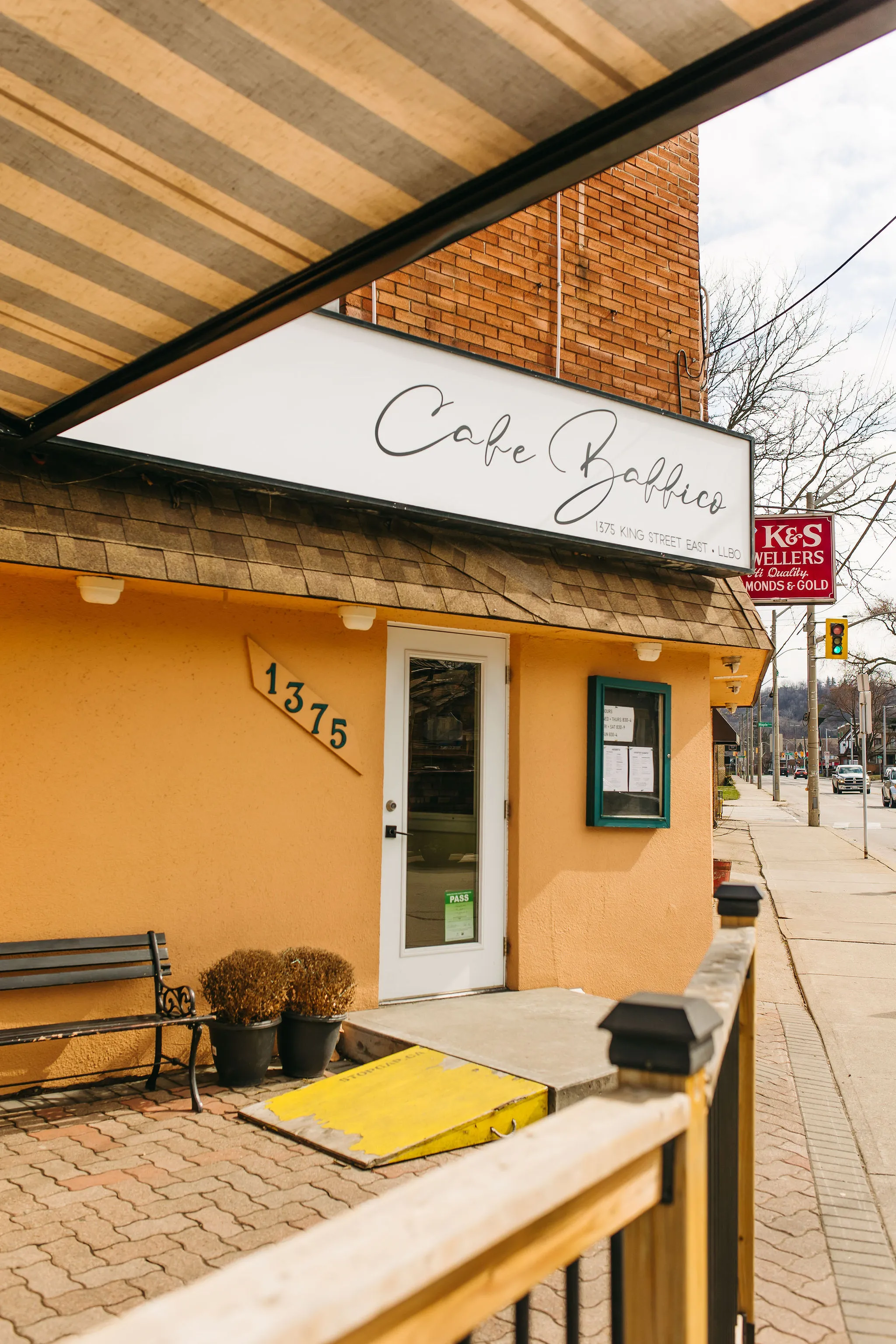 Close-up of a yellow origami crane with many colorful origami cranes blurred in the background.