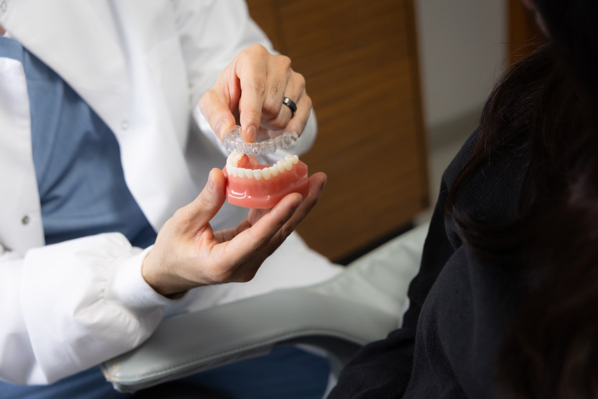 Dentist showing dental model to patient during consultation