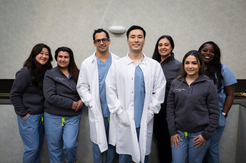 Team photo of dental practice staff posing together in professional setting