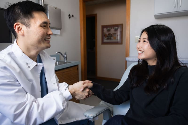 Dentist shaking hands with patient in professional consultation meeting
