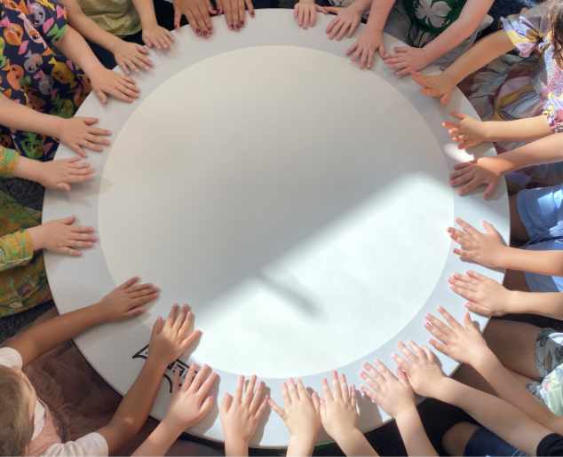 photo of hands around a circular table