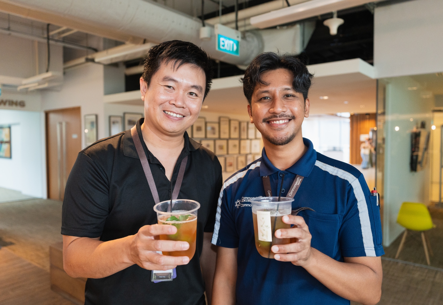 Two men holding a cup, smiling for the camera