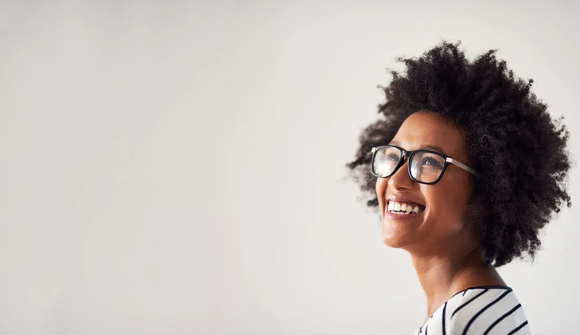 Happy customer wearing prescription glasses after comprehensive eye test at opticians