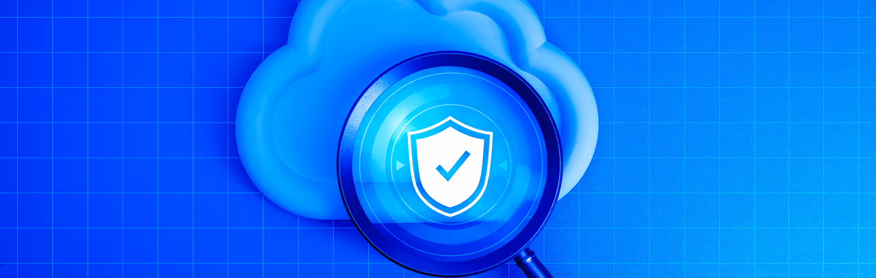Magnifying glass highlighting a shield with a checkmark in front of a cloud symbol on a blue grid background, representing cloud security.